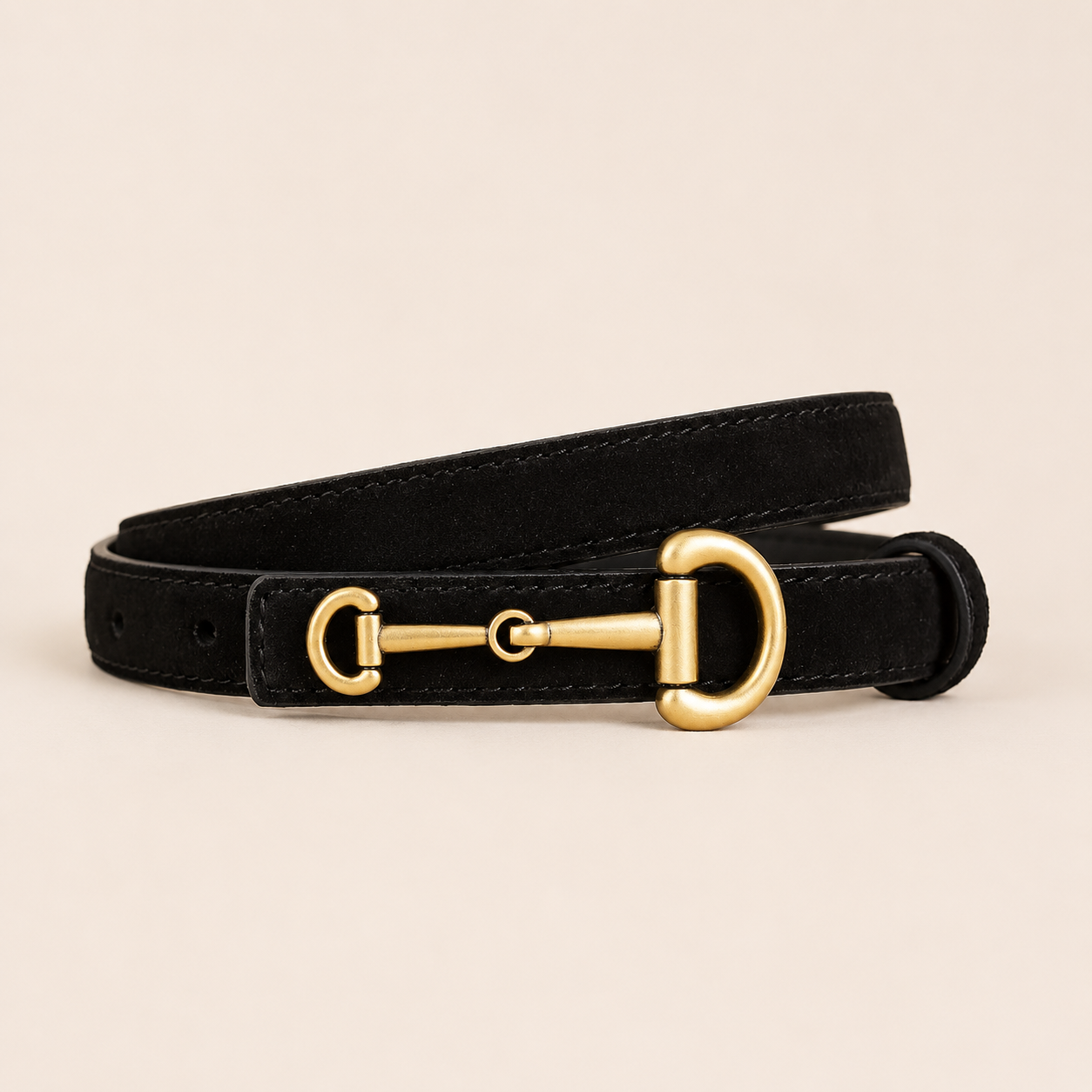 Black leather dog collar with a gold metal buckle on a beige background