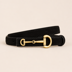 Black leather dog collar with a gold metal buckle on a beige background