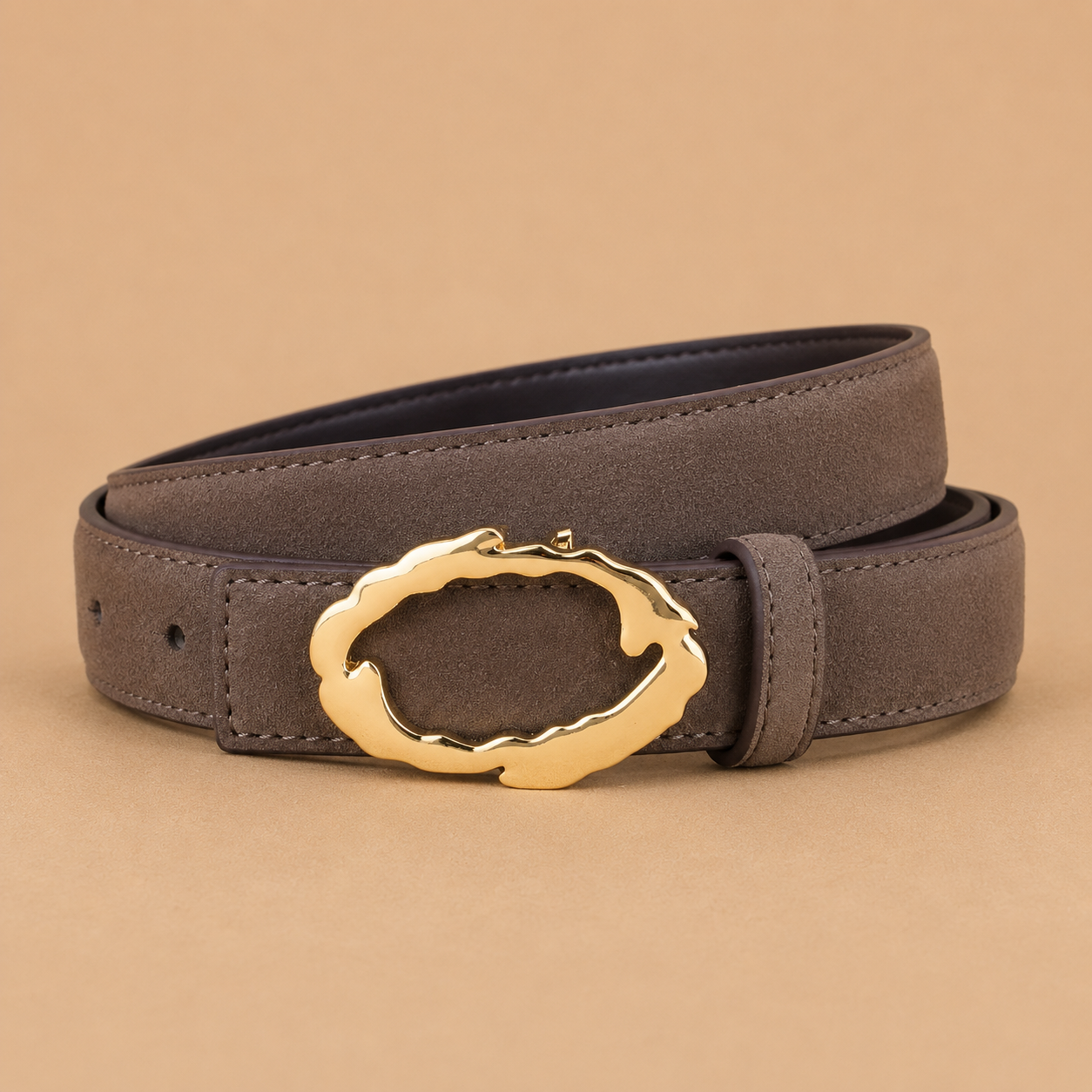 Gray belt with a gold buckle on a beige background