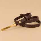 Brown leather belt with a gold buckle on a beige background